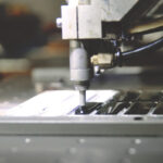 A machine processing a piece of metal.